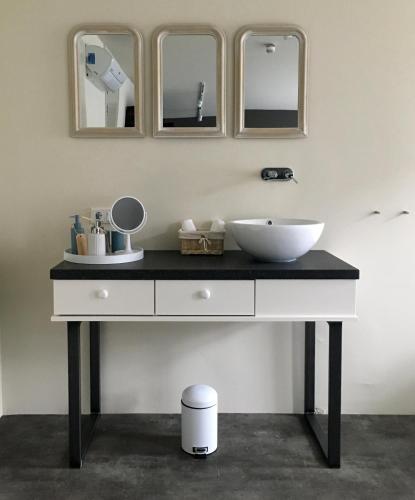 a bathroom with a sink and three mirrors at Slot Oostende in Goes