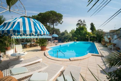 einen Pool mit Stühlen und einem Sonnenschirm in der Unterkunft Appartamento con Piscina in Villa (Galatina) in Galatina