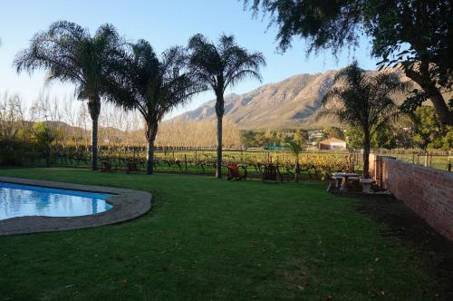 a park with a pool and trees and a mountain at Long Acres Cottages in Montagu