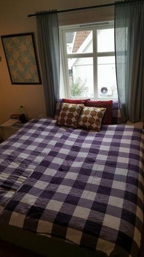 a bedroom with a checkered bed with a window at Egil's Vacation House in Lillehammer
