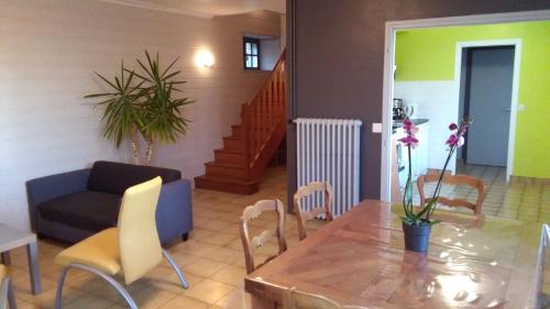 a living room with a table and chairs and a couch at Chez Maria in Guerlédan