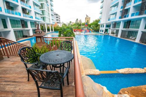 a patio with a table and chairs next to a swimming pool at My Resort Hua Hin in Hua Hin