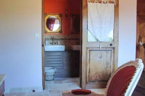 een badkamer met een wastafel en een deur met een spiegel bij Chambres d'hôtes Aux Portes de Bréhat in Ploubazlanec