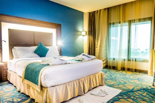 a hotel room with a large bed with towels on it at Novotel Yanbu Albahr in Yanbu