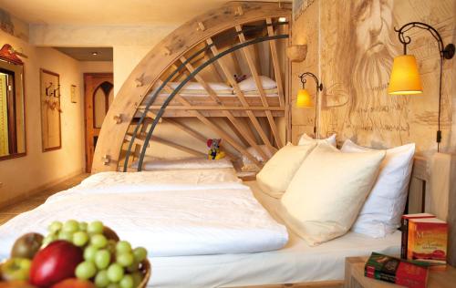 a bedroom with a large bed with a wooden headboard at 4-Sterne Superior Erlebnishotel Colosseo, Europa-Park Freizeitpark & Erlebnis-Resort in Rust