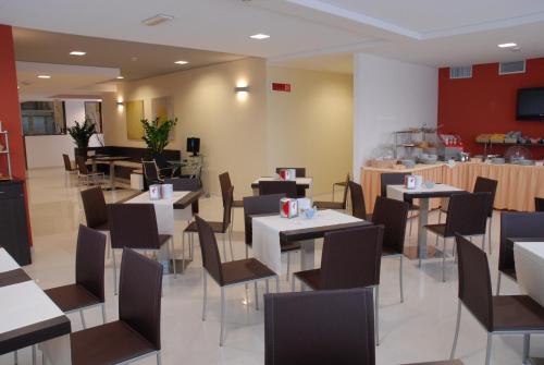 een restaurant met tafels en stoelen in een kamer bij San Giorgio Hotel in San Giórgio di Nogaro