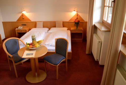 Longostagnoにあるホテル レングステインエロフのベッド、テーブル、椅子が備わるホテルルームです。