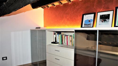 a shelf with books and pictures on top of it at Appartamento Via Mazzini in Rovigo