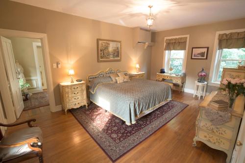 a bedroom with a bed and two night stands and two windows at Hollinger House in Lancaster