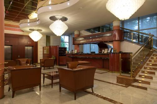 eine Lobby eines Hotels mit Stühlen und einer Treppe in der Unterkunft Arbat Hotel in Moskau