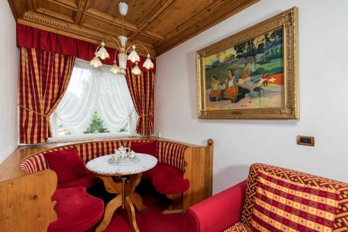 a living room with a red couch and a table at Sporthotel Arabba in Arabba