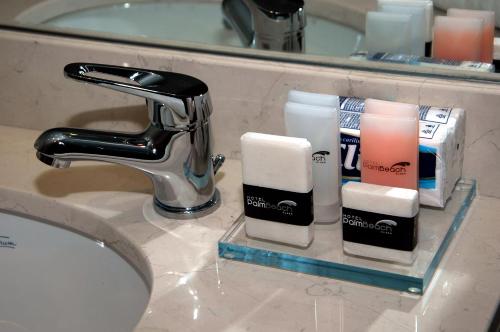 a bathroom sink with a faucet and complimentary toiletries at Palm Beach Plaza Hotel in Montevideo