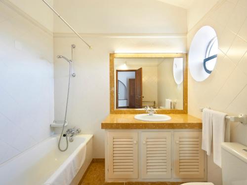 a bathroom with a sink and a tub and a mirror at Quinta do Campo in Nazaré