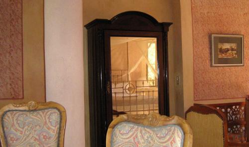 a mirror on a wall with two chairs in a room at Al Moudira Hotel in Luxor