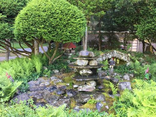 a garden with a fountain and rocks and trees at Slide Mountain Forest House in Oliverea