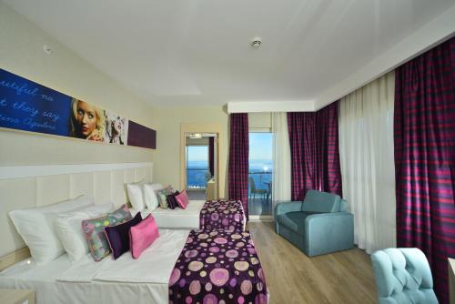 um quarto de hotel com uma cama e uma cadeira em Azura Deluxe Resort & Spa - Ultra All Inclusive em Avsallar