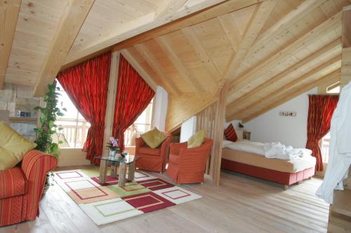 a living room with red furniture and a wooden ceiling at Chalet Nada in Livigno
