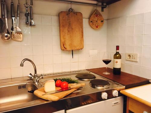 a kitchen with a sink with a cutting board of cheese and wine at Annesso in Vagliagli