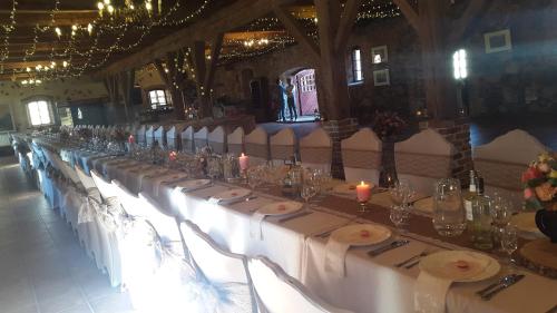 a long table with candles in a room at Cantervilla Castle in Otepää