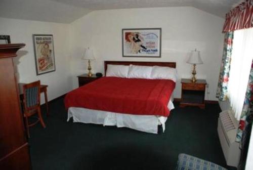 a bedroom with a bed with a red blanket at Historic Beaver Dam Lodge, Golf & RV Resort in Littlefield