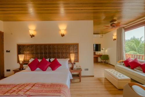 a bedroom with a large bed with red pillows at Araamu Hotels Maldives at Dhiffushi in Dhiffushi
