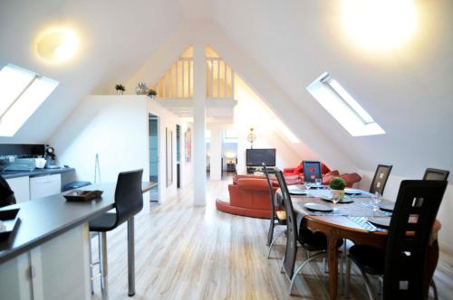 a kitchen and living room with a table and a couch at Creativ Appart in Saint-Cyr-lʼÉcole