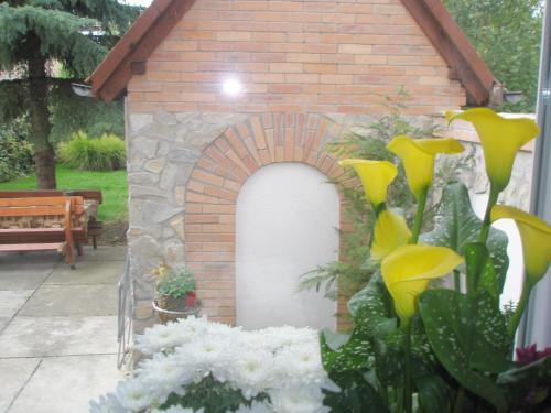 a brick building with a brick arch in a yard at Helga Vendégház in Budaörs