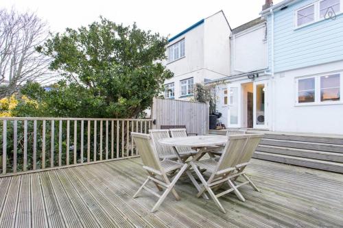 a table and chairs on a wooden deck at Fisherman's Cottage in Saint Mawes