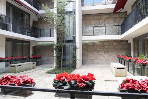 a group of red flowers in a courtyard at Casas do Teatro in Porto