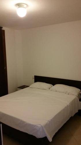カステルサルドにあるAppartamento Paradisoのベッドルーム(白いシーツを使用した大型ベッド1台付)