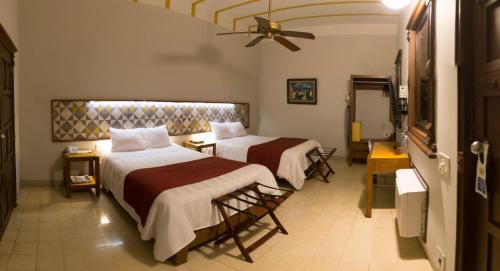 a hotel room with two beds and a ceiling fan at Hotel Caribe Merida Yucatan in Mérida