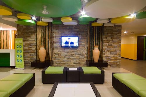 vestíbulo con muebles verdes y amarillos y TV en Go Hotels Puerto Princesa, en Puerto Princesa City