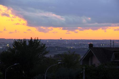 a sunset with a view of a city at B&B Vista su Roma in Marco Simone
