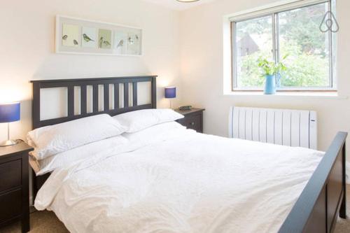 a large white bed in a bedroom with a window at Bright Oxford Apartment in Oxford