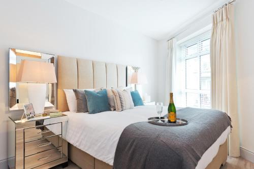 a bedroom with a large bed with a bottle of wine at Exclusive City Centre Apartment in Dublin