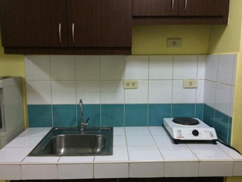 a kitchen with a sink and a toaster on the counter at Leons Den is a long term accomodation of atleast 1 month stay in Manila