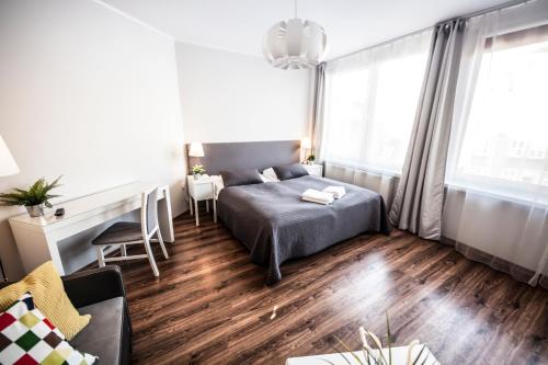 a small bedroom with a bed and a desk at Apartamenty Baszta in Gdańsk