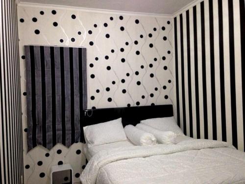 Schlafzimmer mit einem Bett mit schwarzen und weißen Streifen in der Unterkunft apartemen mediterania garden in Jakarta