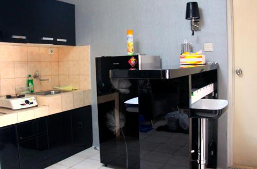 una cocina con encimera negra y fregadero en apartemen mediterania garden en Yakarta