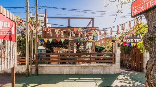 a store with flags and a bench in front of it at The Trip Hostel in Punta del Este