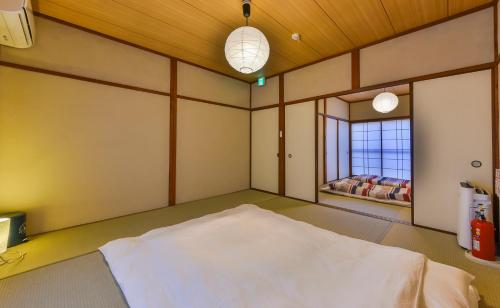 Cette chambre comprend un grand lit blanc. dans l'établissement Yuenshe Sanjusangendo Villa, à Kyoto