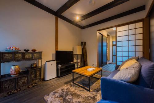 a living room with a blue couch and a table at Yuenshe Sanjusangendo Villa in Kyoto