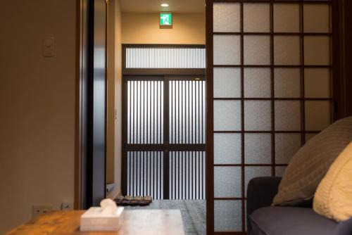 a room with a japanese door with a table in front at Yuenshe Sanjusangendo Villa in Kyoto