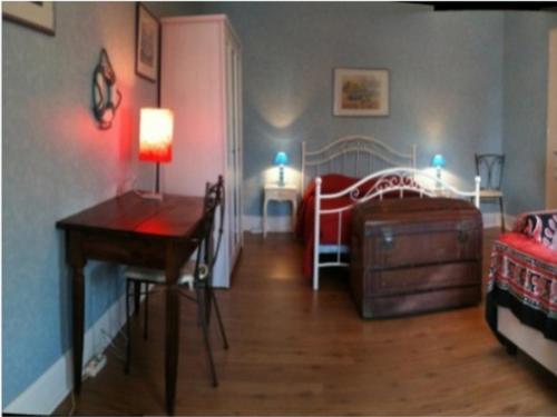 Habitación con escritorio y dormitorio con cama. en Chambres et Tables d'Hotes Les Breuils, en Mariol