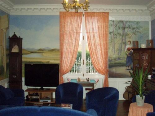 un salon avec une télévision et une grande fenêtre dans l'établissement Chambres et Tables d'Hotes Les Breuils, à Mariol