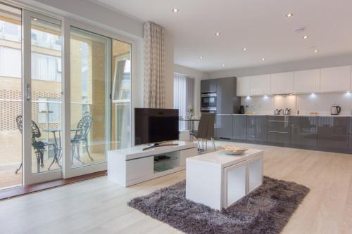 a large living room with a tv and a kitchen at Citystay Living - Vesta Apartments in Cambridge