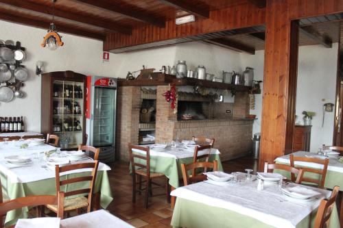 a dining room with tables and chairs and a fireplace at Locanda San Giorgio in Sestola