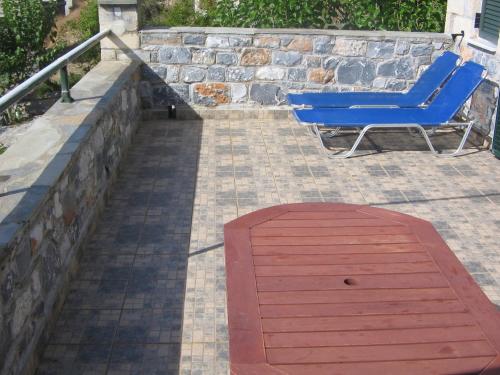 a blue chair and a table on a patio at Katafigio Holiday Homes in Riglia