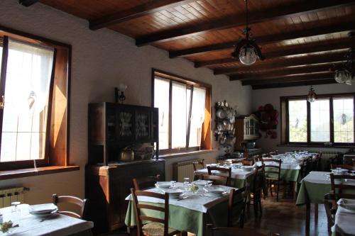 a dining room with tables and chairs and windows at Locanda San Giorgio in Sestola