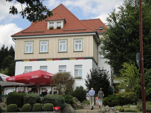un gran edificio blanco con techo rojo en Gasthaus Brockenhėxe mit Restaurant & Café, en Schierke
